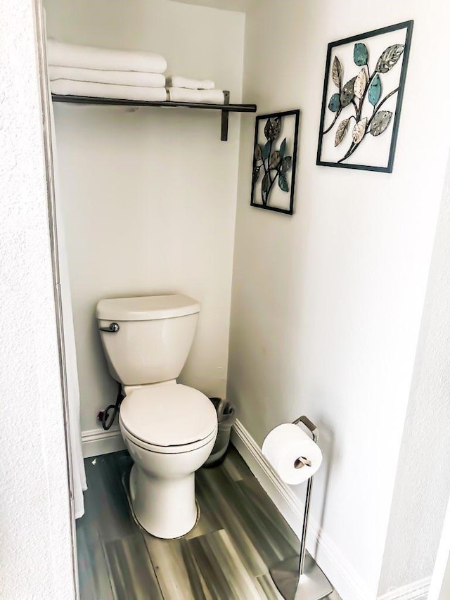 bathroom featuring hardwood / wood-style flooring and toilet