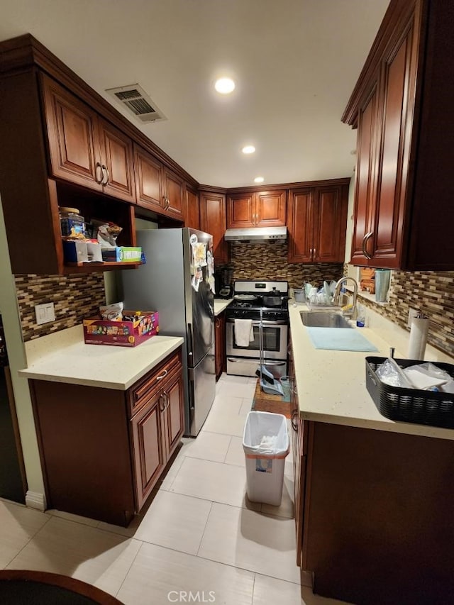 kitchen featuring decorative backsplash, sink, light tile patterned flooring, and appliances with stainless steel finishes