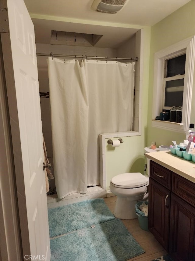 bathroom featuring a shower with shower curtain, vanity, and toilet