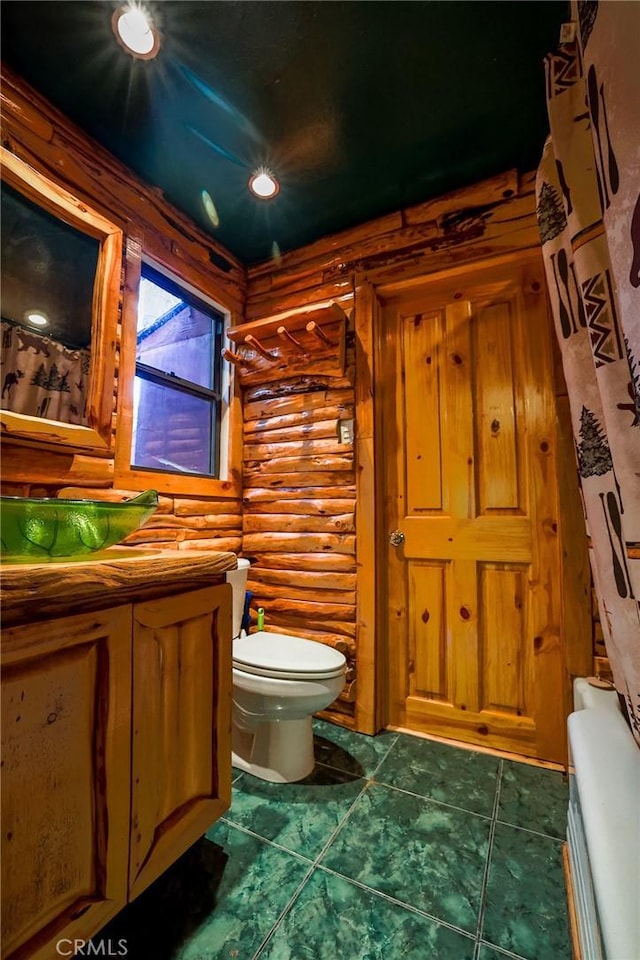 bathroom featuring tile patterned floors, toilet, and log walls