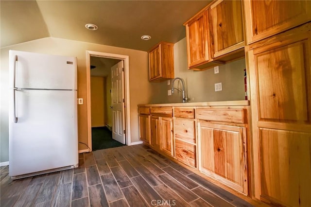 kitchen with white fridge, sink, and dark wood-type flooring