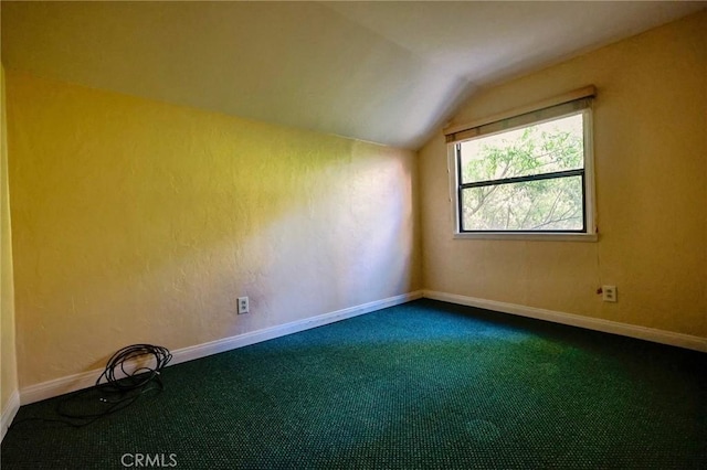 empty room featuring carpet and lofted ceiling