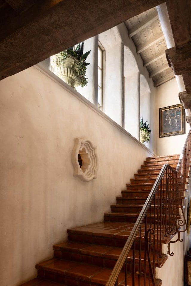 staircase featuring lofted ceiling with beams and wooden ceiling