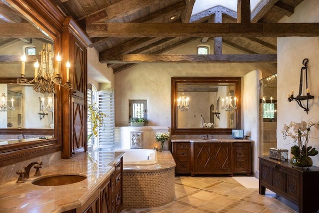 bathroom featuring a wealth of natural light, lofted ceiling with beams, vanity, and tiled tub