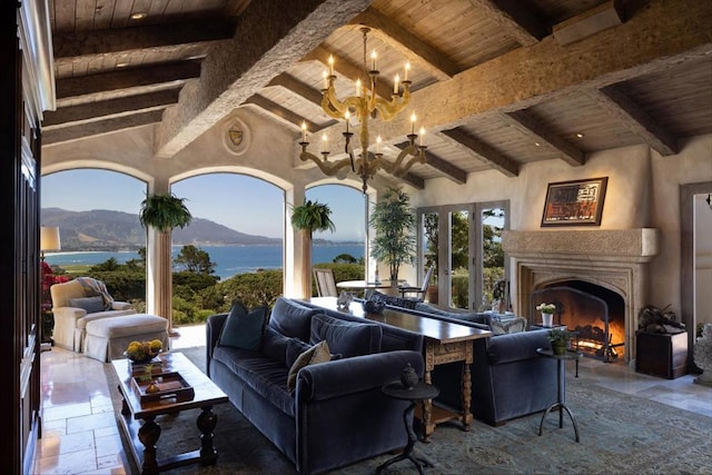 patio terrace at dusk featuring an outdoor living space with a fireplace, ceiling fan, and a water and mountain view