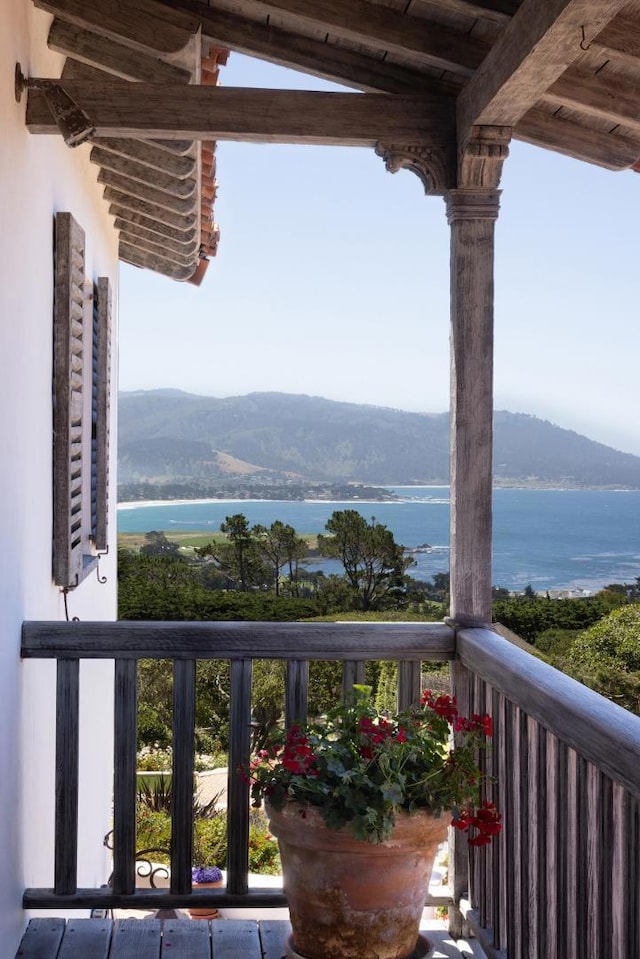 balcony featuring a water and mountain view