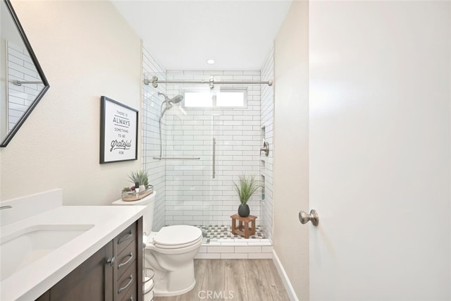 bathroom featuring hardwood / wood-style flooring, vanity, toilet, and walk in shower