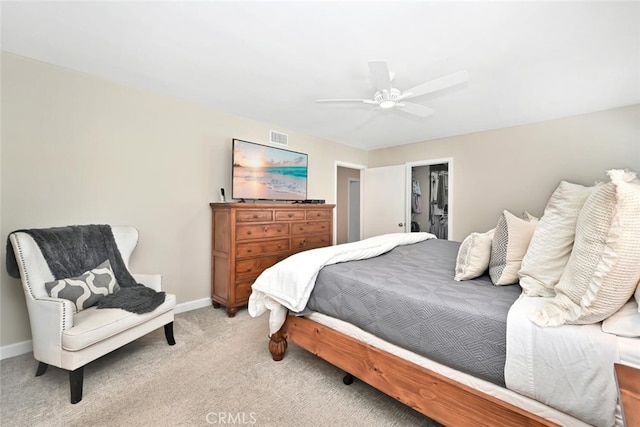 carpeted bedroom featuring a closet, a spacious closet, and ceiling fan