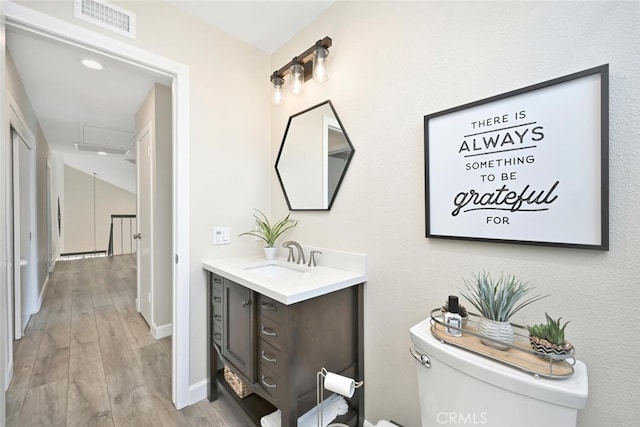 bathroom with hardwood / wood-style flooring, vanity, and toilet