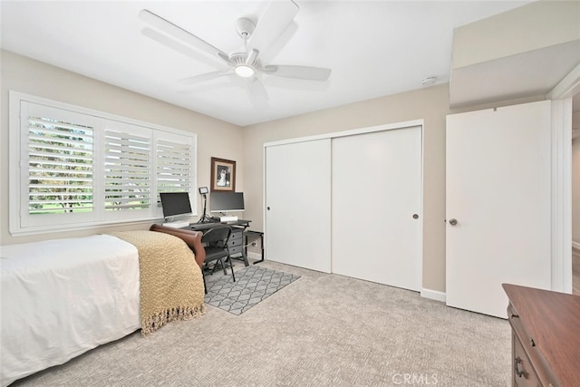 bedroom with ceiling fan, a closet, and light carpet