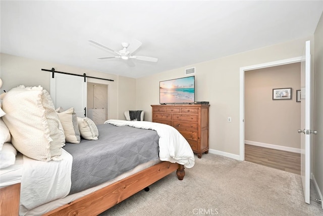 bedroom with carpet flooring, a barn door, and ceiling fan