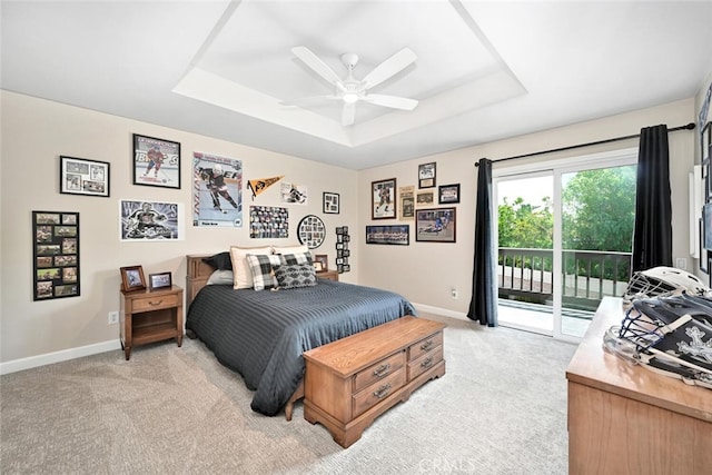 bedroom with a raised ceiling, ceiling fan, access to exterior, and light colored carpet