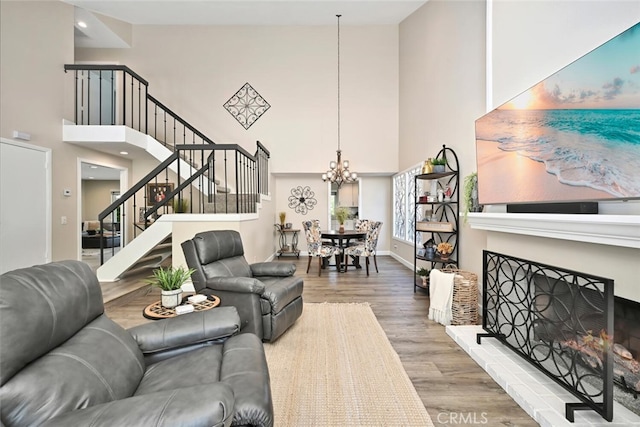 living room featuring a notable chandelier, wood-type flooring, and a towering ceiling