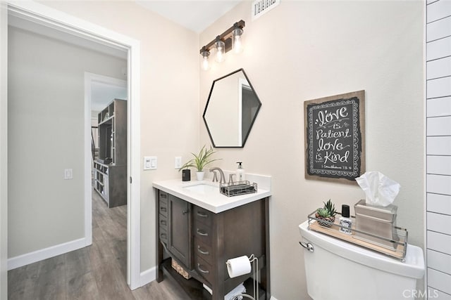 bathroom with hardwood / wood-style floors, vanity, and toilet