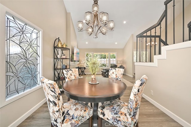 dining space with dark hardwood / wood-style flooring, lofted ceiling, and a notable chandelier