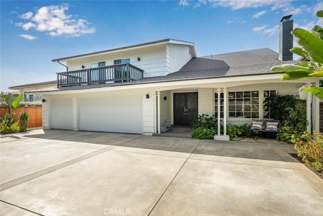 front facade featuring a porch, a balcony, and a garage