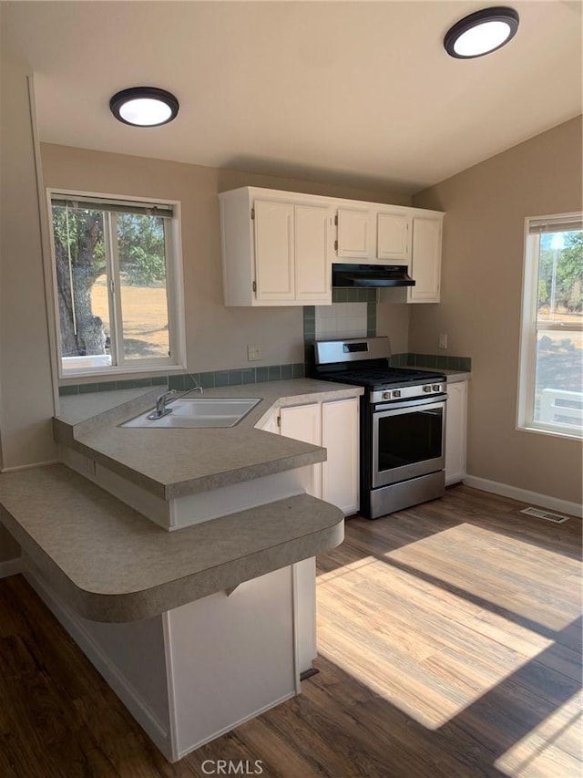 kitchen with wood-type flooring, sink, white cabinetry, and stainless steel gas range oven