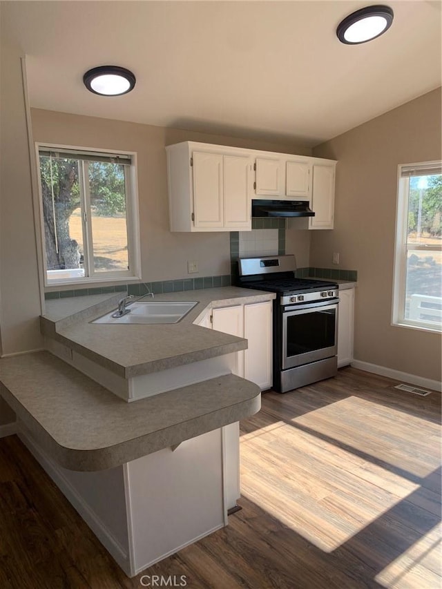 kitchen with sink, stainless steel range with gas stovetop, white cabinetry, and wood-type flooring