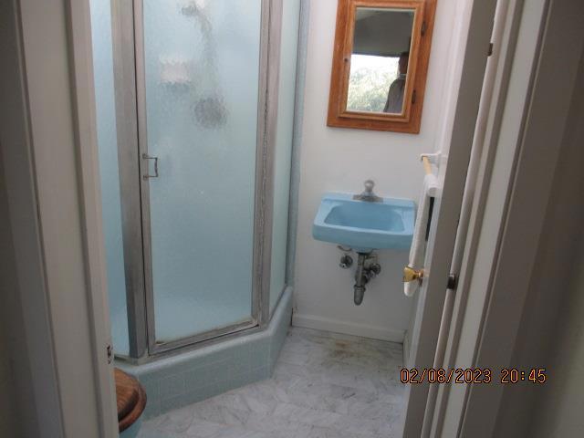 bathroom with a shower with door and sink