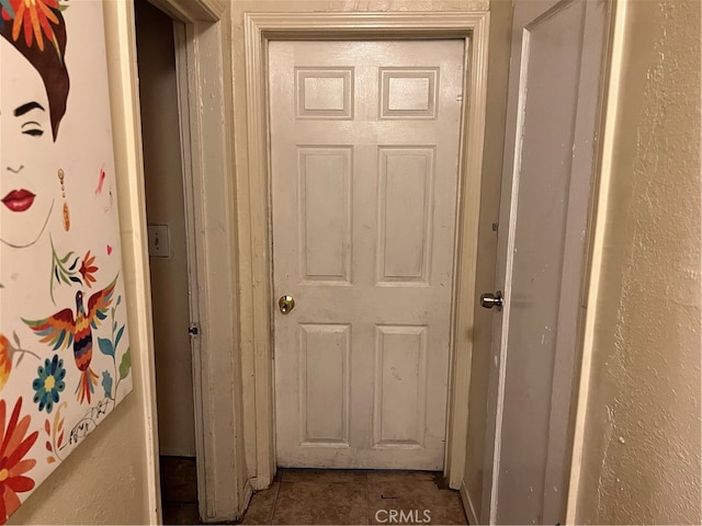 hallway with dark tile flooring