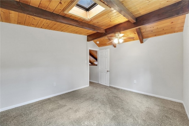 carpeted spare room with lofted ceiling with skylight, ceiling fan, and wood ceiling