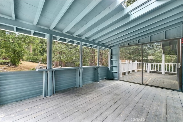 unfurnished sunroom with vaulted ceiling with skylight