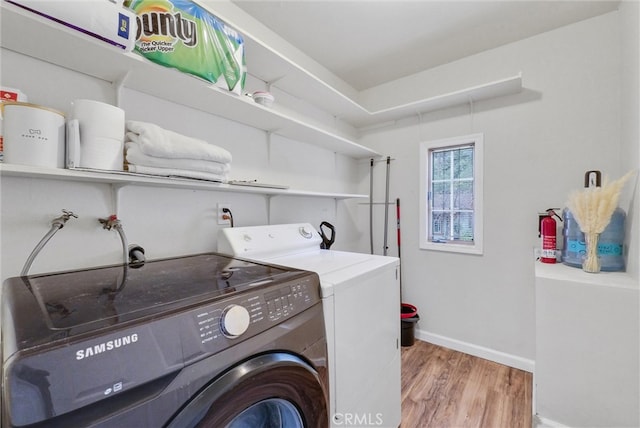 clothes washing area featuring washer and dryer, electric dryer hookup, washer hookup, and light hardwood / wood-style floors