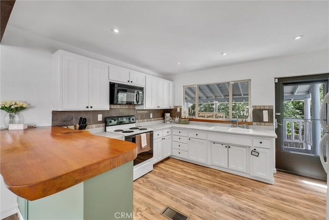 kitchen featuring backsplash, white electric range oven, sink, light wood-type flooring, and white cabinets