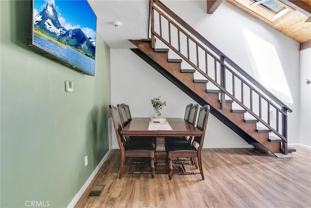 dining space featuring hardwood / wood-style floors and a skylight