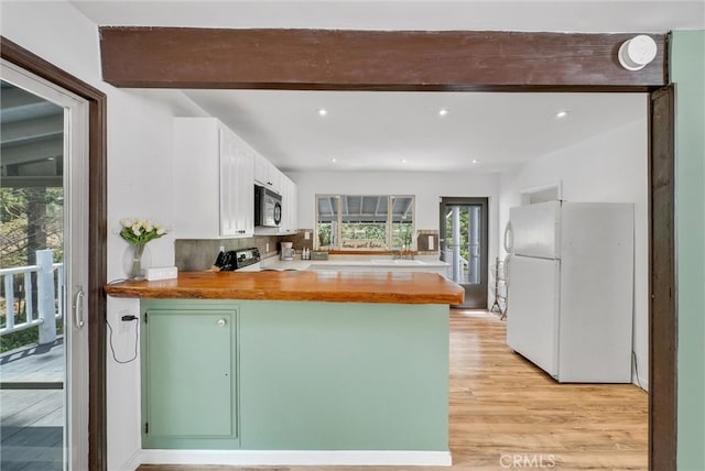 kitchen with range, white cabinetry, kitchen peninsula, light hardwood / wood-style floors, and white refrigerator