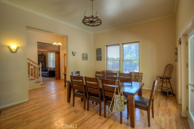 dining space with a notable chandelier, light hardwood / wood-style floors, and ornamental molding