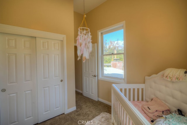 carpeted bedroom featuring a crib and a closet