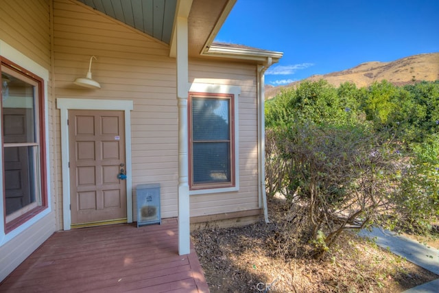 view of exterior entry with a deck with mountain view