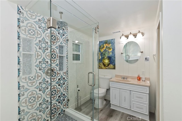 bathroom featuring toilet, a shower with door, wood-type flooring, and large vanity