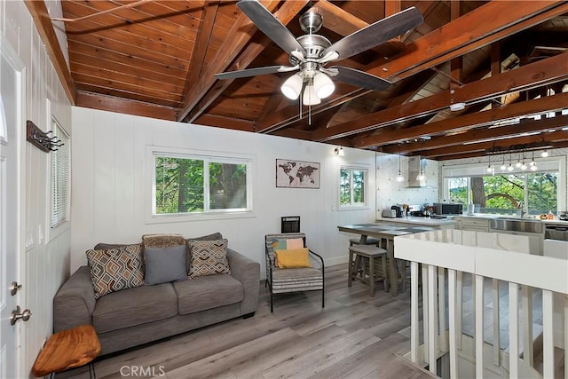 living room with light hardwood / wood-style flooring, ceiling fan, wooden ceiling, and lofted ceiling with beams