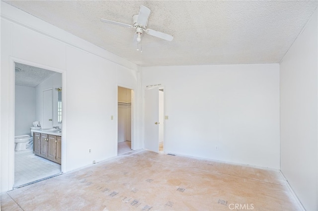 unfurnished room featuring lofted ceiling, ceiling fan, and a textured ceiling