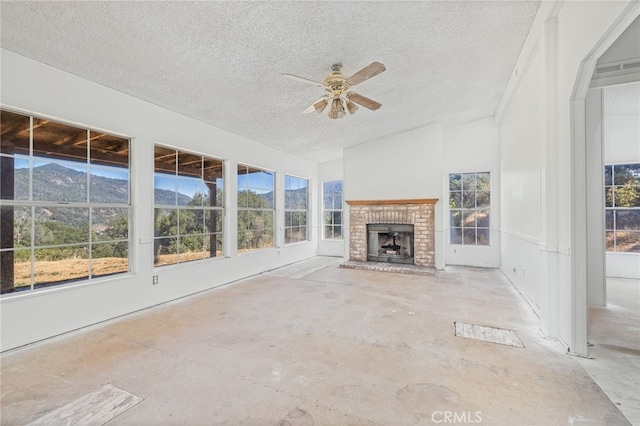 unfurnished sunroom featuring a healthy amount of sunlight, lofted ceiling, and a brick fireplace