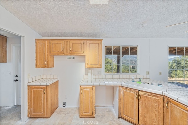 kitchen featuring tile countertops and a textured ceiling