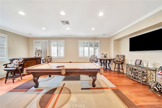 recreation room with pool table, ornamental molding, and light wood-type flooring