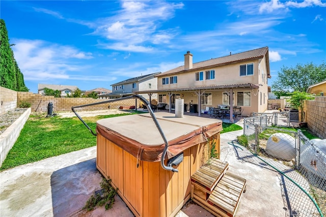 back of property with a patio area and a hot tub