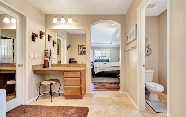 bathroom featuring vanity, tile floors, a tray ceiling, and toilet