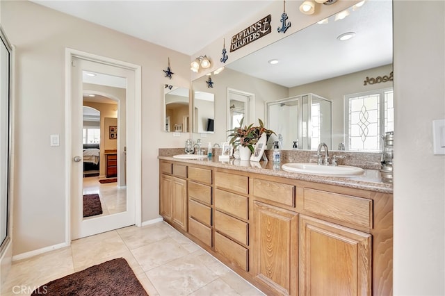 bathroom with tile floors, vanity with extensive cabinet space, and double sink