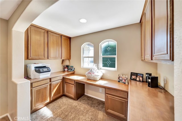 carpeted office featuring built in desk