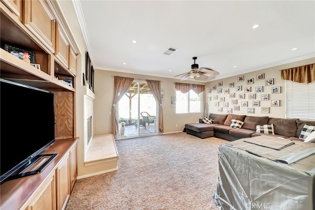 carpeted living room with crown molding and ceiling fan