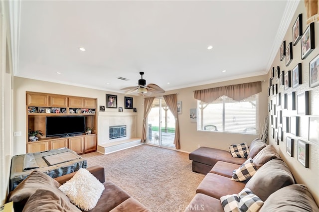 carpeted living room with built in features, ceiling fan, and crown molding