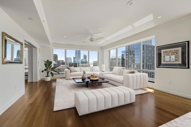 living room with dark hardwood / wood-style flooring, ceiling fan, and a tray ceiling