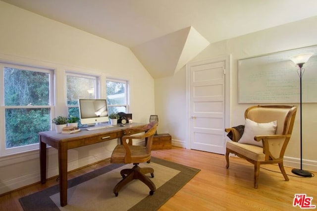 home office featuring lofted ceiling and light hardwood / wood-style flooring