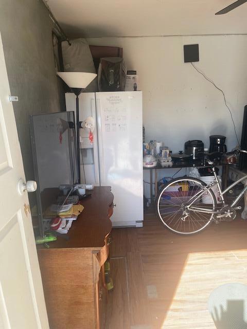 kitchen with white refrigerator with ice dispenser and wood-type flooring