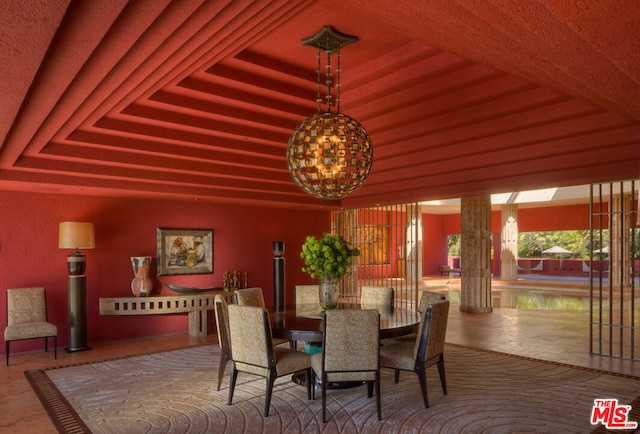 dining space with a raised ceiling and an inviting chandelier