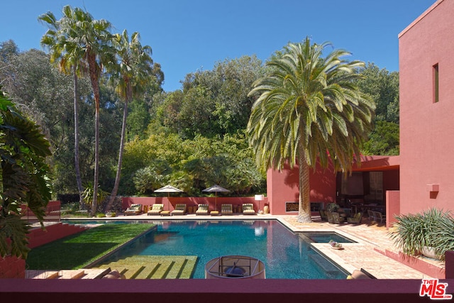 view of pool featuring a hot tub and a fire pit